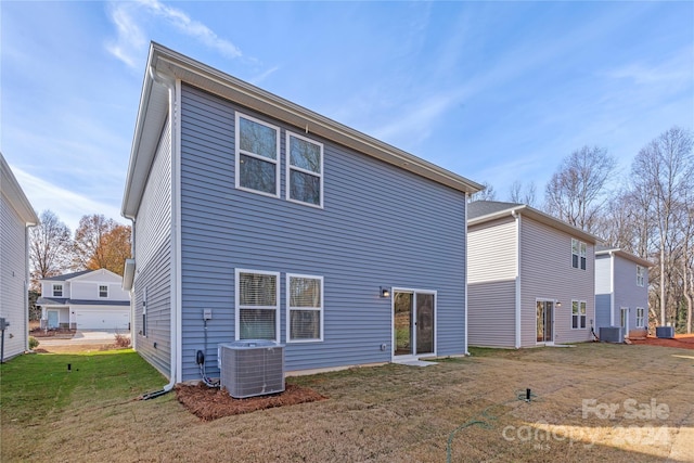 rear view of property with a yard and central AC unit