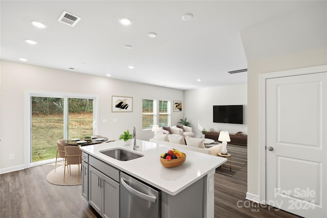 kitchen featuring a kitchen island with sink, dishwasher, sink, and a healthy amount of sunlight