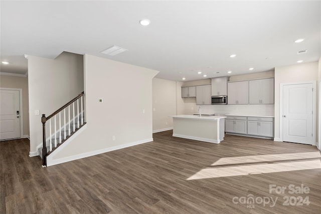 kitchen with tasteful backsplash, sink, an island with sink, and light hardwood / wood-style floors