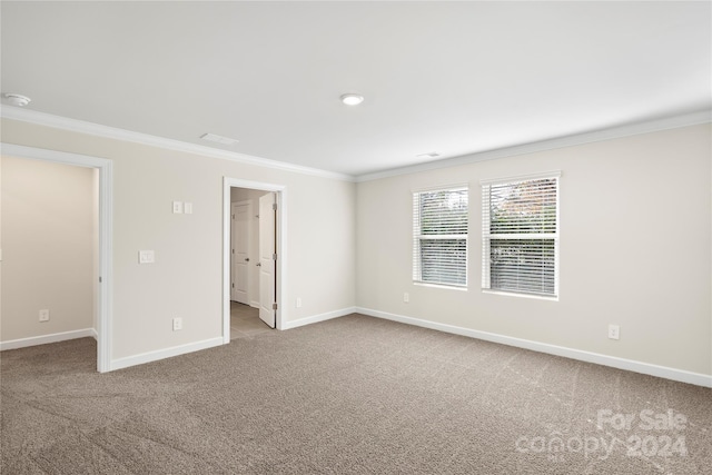 carpeted spare room with crown molding