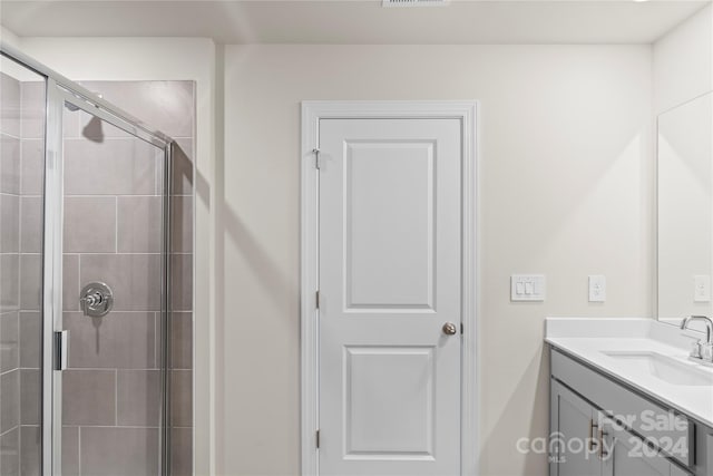 bathroom featuring vanity and a shower with shower door