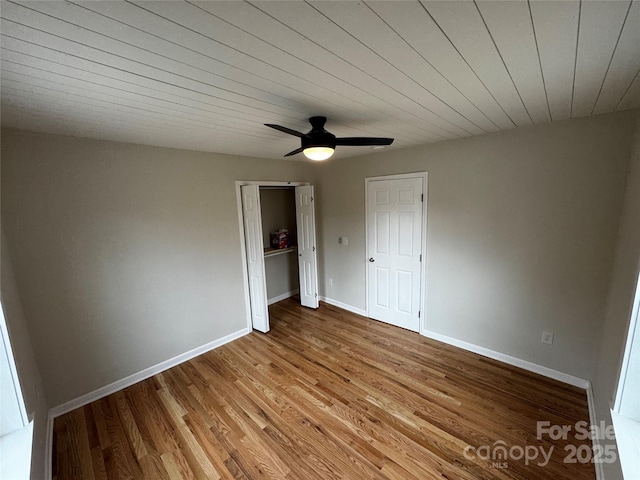 unfurnished bedroom featuring wood ceiling, light hardwood / wood-style flooring, a closet, and ceiling fan