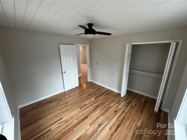 unfurnished bedroom with ceiling fan, light hardwood / wood-style floors, a closet, and wooden ceiling