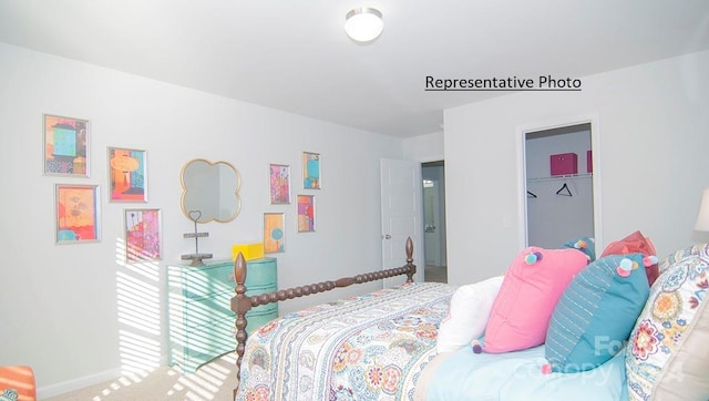 carpeted bedroom featuring a spacious closet and a closet