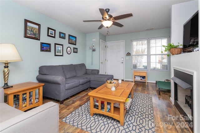 living room featuring ceiling fan and dark wood-type flooring