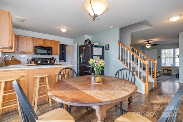 dining space featuring ceiling fan, sink, and dark hardwood / wood-style floors