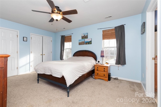 carpeted bedroom featuring multiple windows and ceiling fan