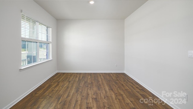 unfurnished room with dark hardwood / wood-style flooring