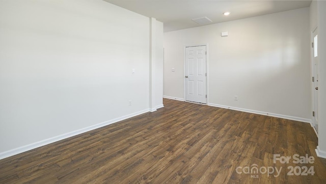 unfurnished room featuring dark wood-type flooring