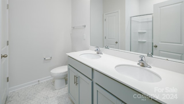 bathroom featuring tile patterned flooring, vanity, and toilet