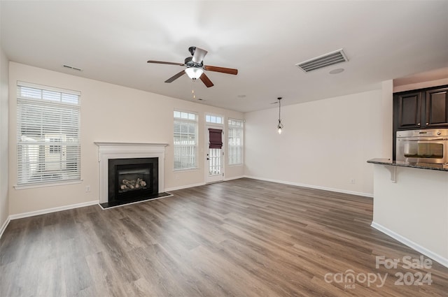 unfurnished living room with dark hardwood / wood-style floors and ceiling fan