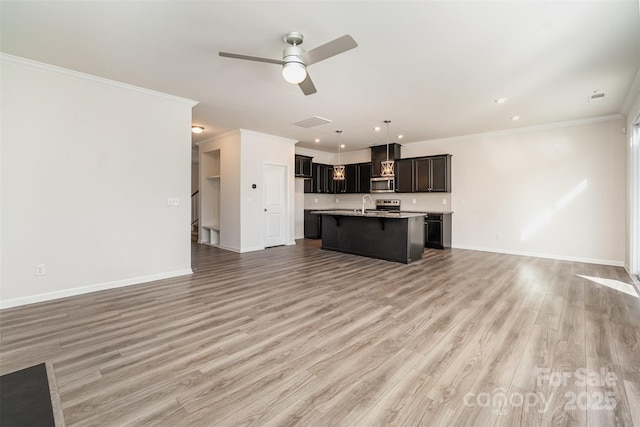 unfurnished living room featuring ceiling fan, hardwood / wood-style floors, ornamental molding, and sink