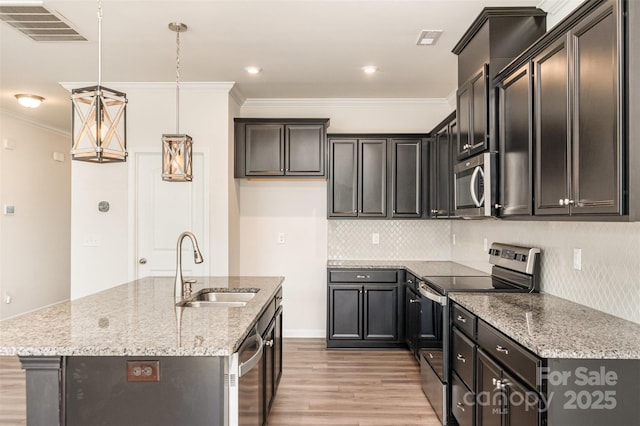 kitchen featuring light stone countertops, pendant lighting, stainless steel appliances, a center island with sink, and sink