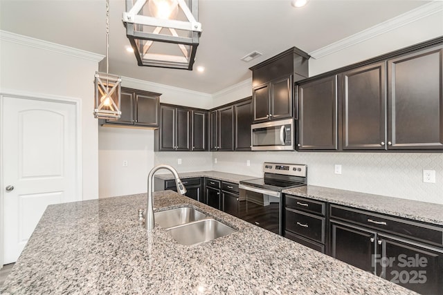 kitchen with appliances with stainless steel finishes, light stone counters, and sink