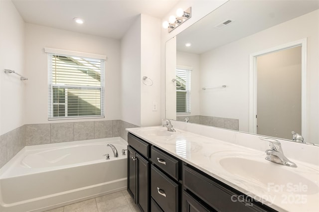 bathroom featuring a tub to relax in, vanity, and tile patterned floors