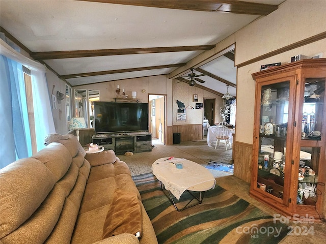 carpeted living room with ceiling fan, wooden walls, and lofted ceiling with beams