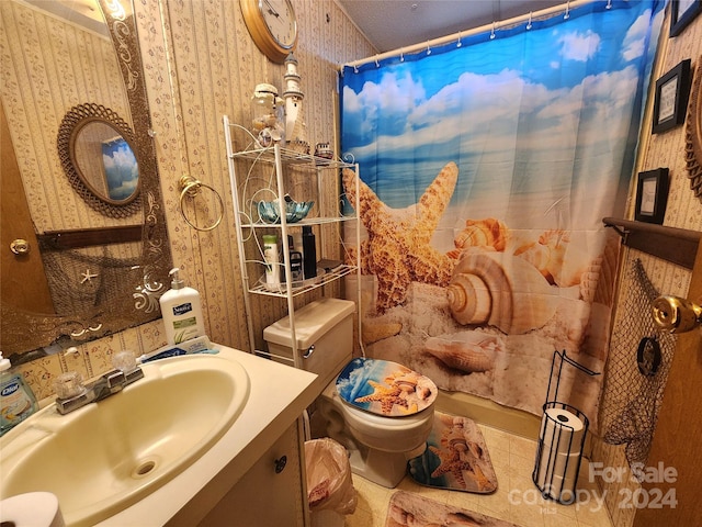 bathroom featuring tile patterned floors, vanity, curtained shower, and toilet