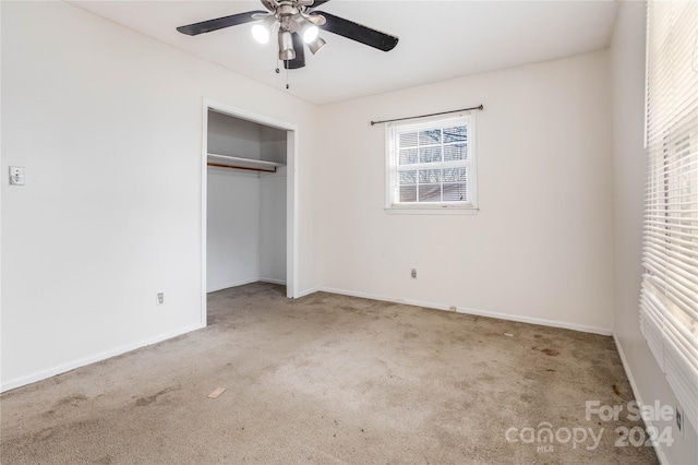 unfurnished bedroom with ceiling fan, light colored carpet, and a closet