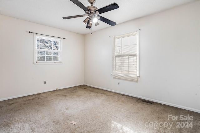 carpeted spare room with ceiling fan and a wealth of natural light