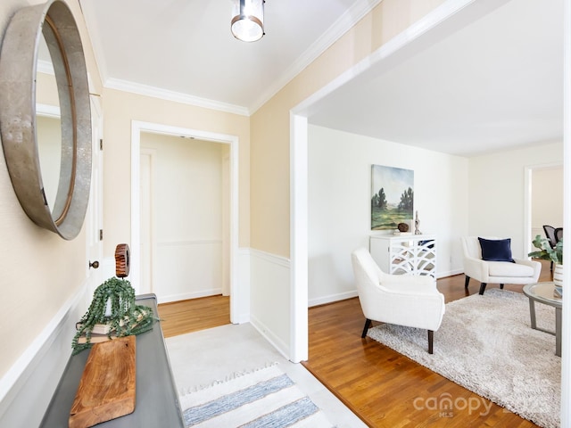 living area featuring light wood-type flooring and ornamental molding