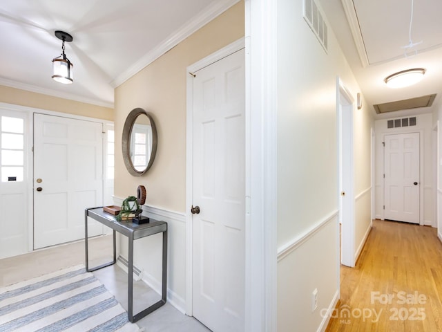 entrance foyer with ornamental molding and light wood-type flooring