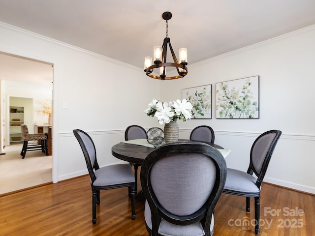 dining room with hardwood / wood-style floors, a notable chandelier, and crown molding