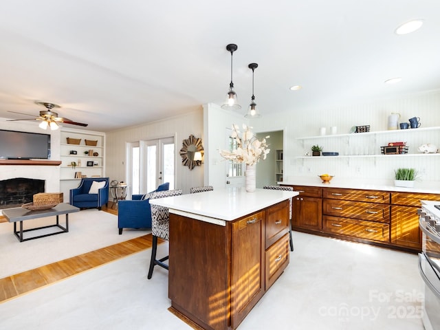 kitchen featuring french doors, hanging light fixtures, built in shelves, a fireplace, and a kitchen island