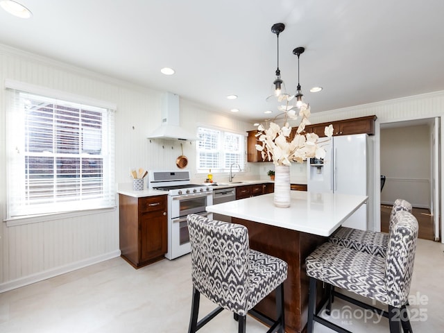 kitchen featuring a center island, crown molding, white appliances, and premium range hood