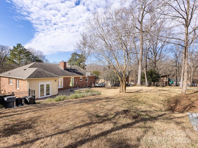 view of yard with a playground and french doors