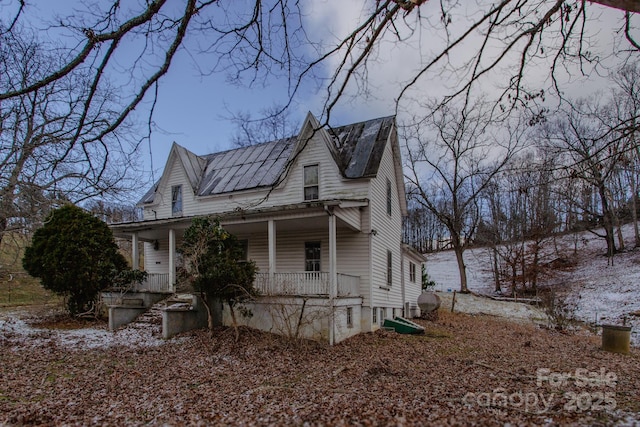 view of side of home with solar panels and a porch