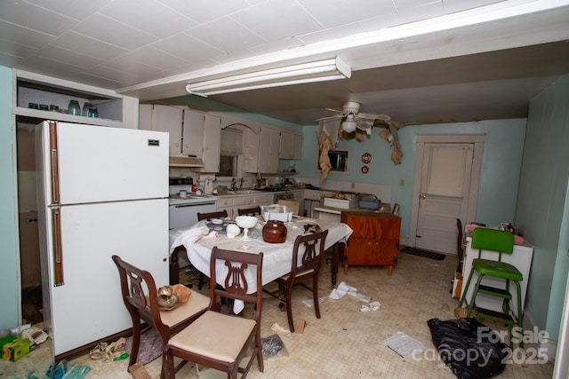 kitchen featuring white fridge, white cabinetry, ceiling fan, and sink