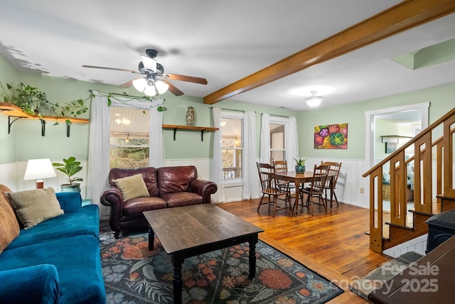 living room with beamed ceiling, ceiling fan, and wood-type flooring