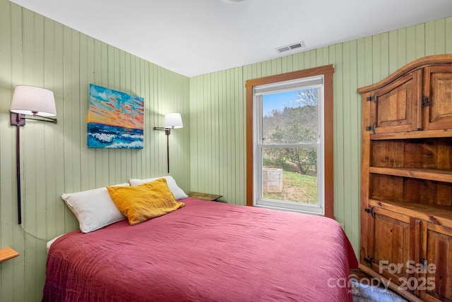 bedroom featuring wood walls