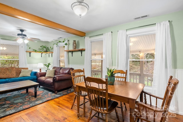 dining area with beamed ceiling, ceiling fan, and hardwood / wood-style flooring