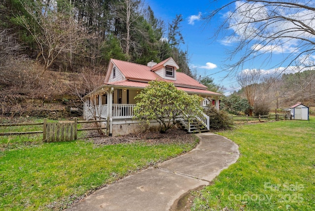 view of front of house featuring a shed, a front lawn, and a porch