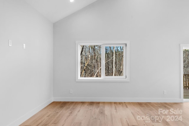 unfurnished room featuring plenty of natural light, high vaulted ceiling, and light wood-type flooring