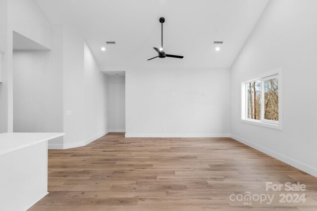 unfurnished living room featuring light wood-type flooring, high vaulted ceiling, and ceiling fan