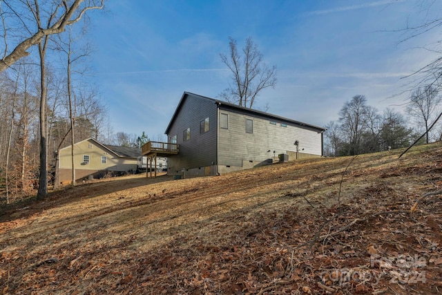 back of property with central AC unit and a wooden deck