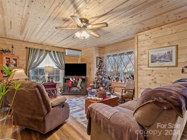 living room featuring hardwood / wood-style floors, wooden walls, and a healthy amount of sunlight