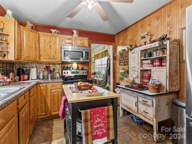 kitchen featuring butcher block counters, stainless steel appliances, crown molding, and wooden walls