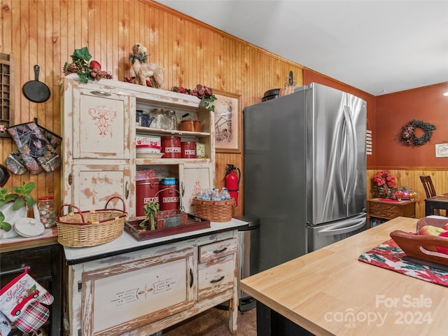 kitchen with stainless steel refrigerator and wooden walls