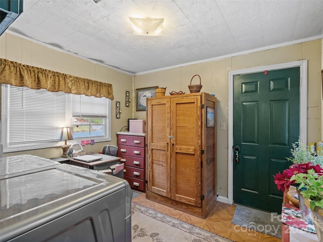 washroom with light parquet flooring, ornamental molding, and washing machine and clothes dryer