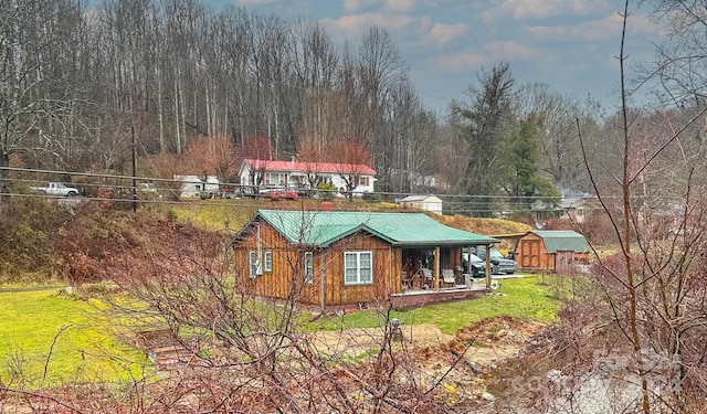 view of side of home featuring a porch and a lawn