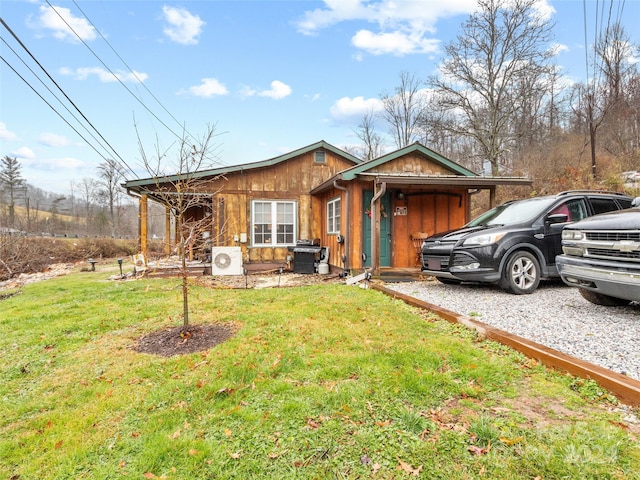 view of front of property featuring ac unit and a front lawn