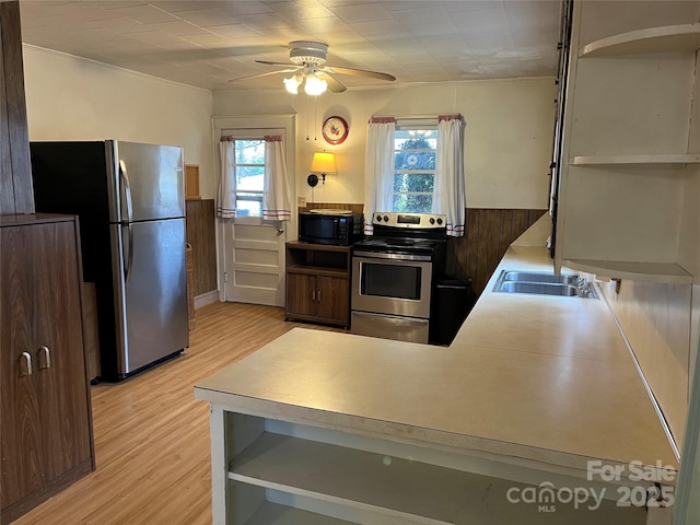 kitchen with sink, a wealth of natural light, light hardwood / wood-style flooring, and stainless steel appliances