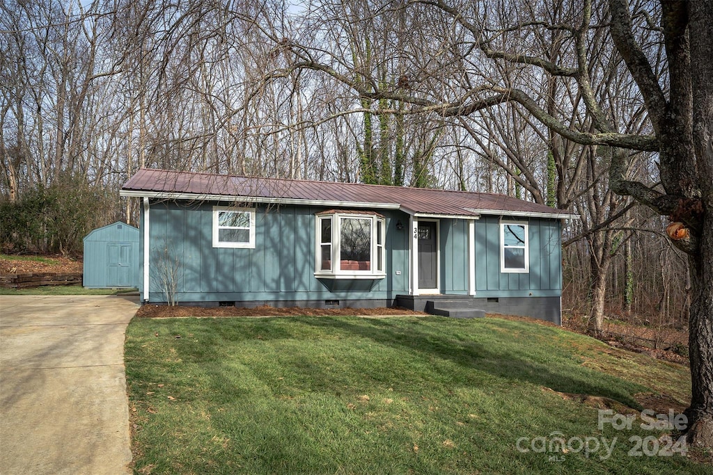 view of front facade with a shed and a front lawn