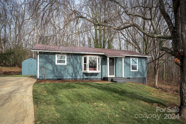 view of front facade with a shed and a front lawn