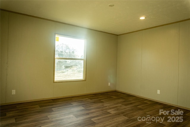 empty room with crown molding and dark hardwood / wood-style flooring