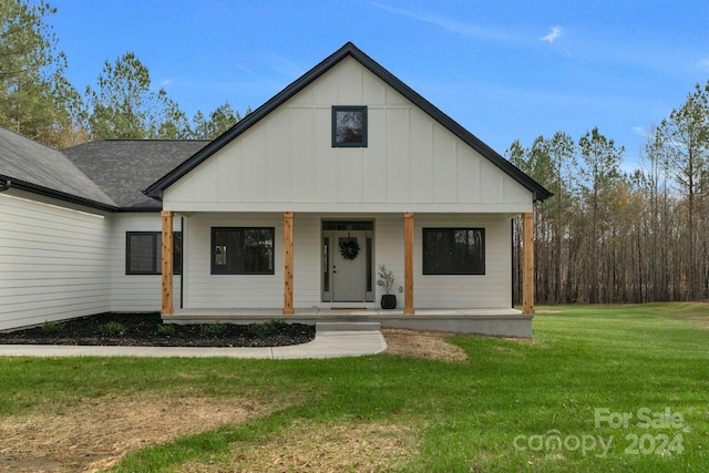 modern farmhouse style home with a front lawn and a porch