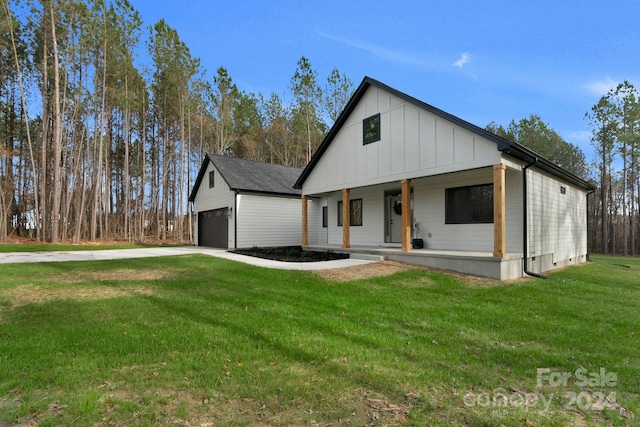 modern farmhouse featuring a front yard, a porch, and a garage